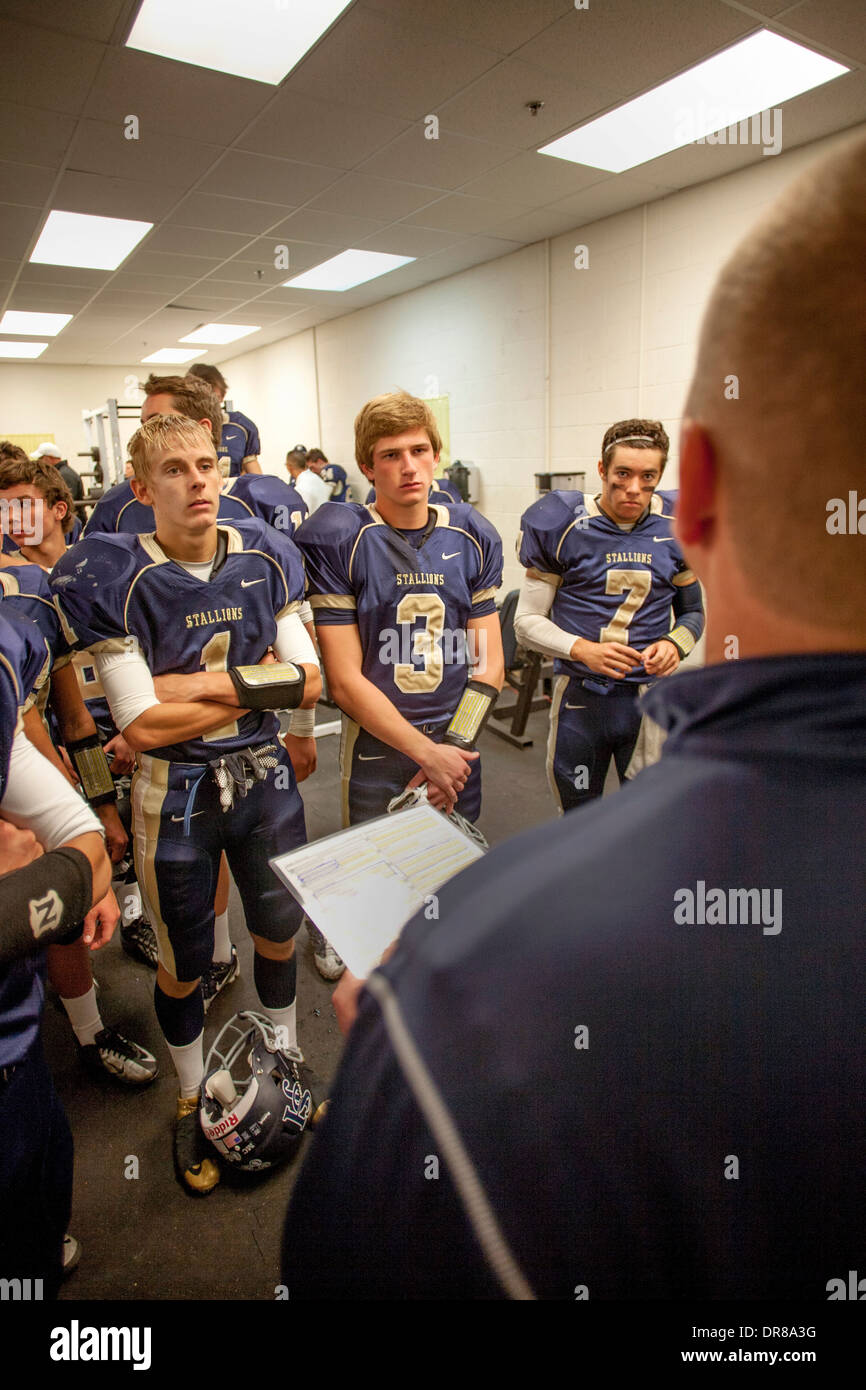High school football players listen to their coach during half time of a night game in San Juan Capistrano, CA. Stock Photo