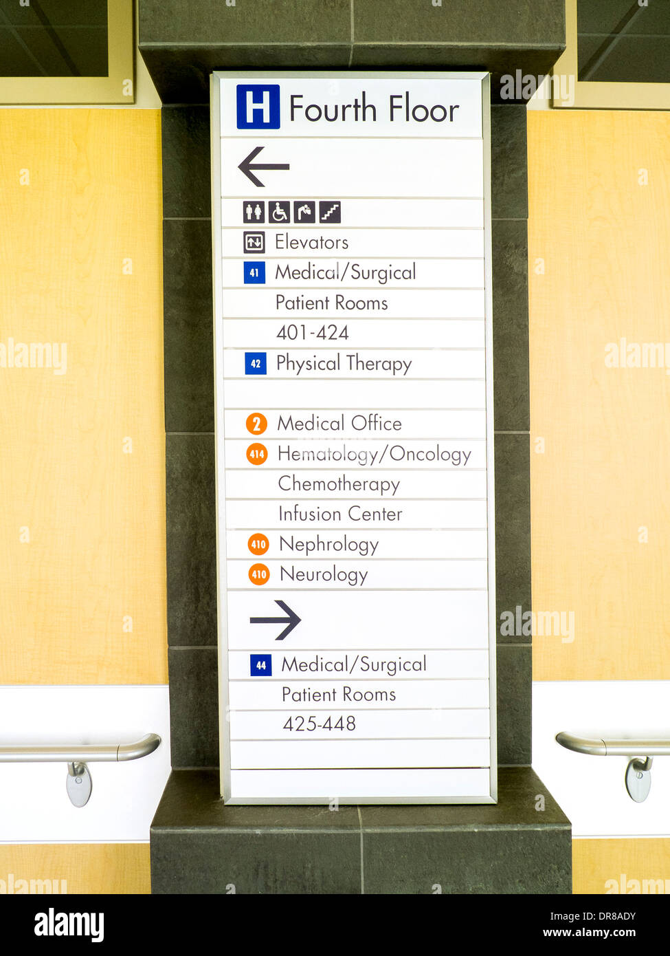 A sign in the hallway of a Southern California hospital points out directions to various medical departments. Stock Photo