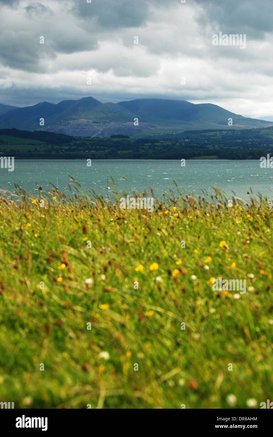View of the Snowdon Mountain Range across the Straits of Menai, with Anglesey in the foreground Stock Photo
