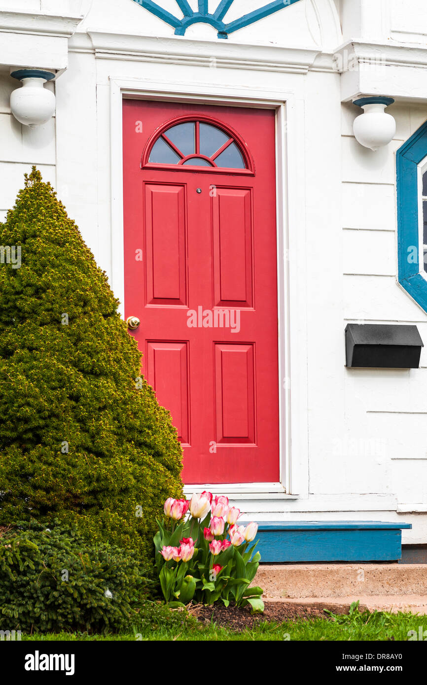 A red front door of an older traditional style American type home. Stock Photo