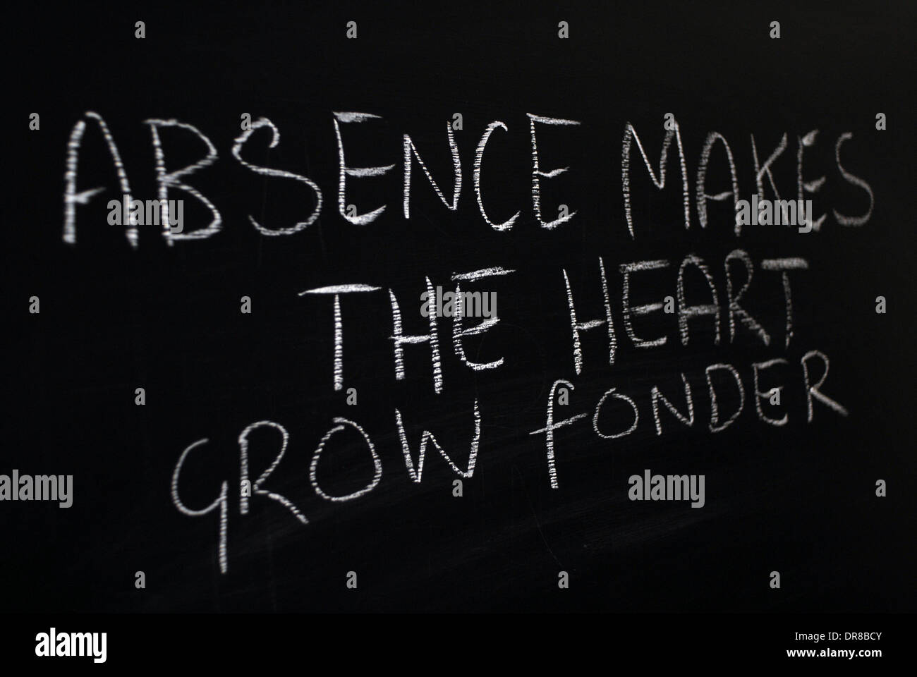 chalk writing -  absence makes the heart grow fonder. - words written on blackboard. Stock Photo