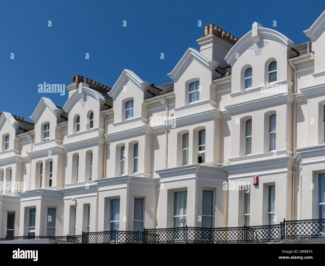 Sunlit white painted Victorian Terrace seafront front facade of the