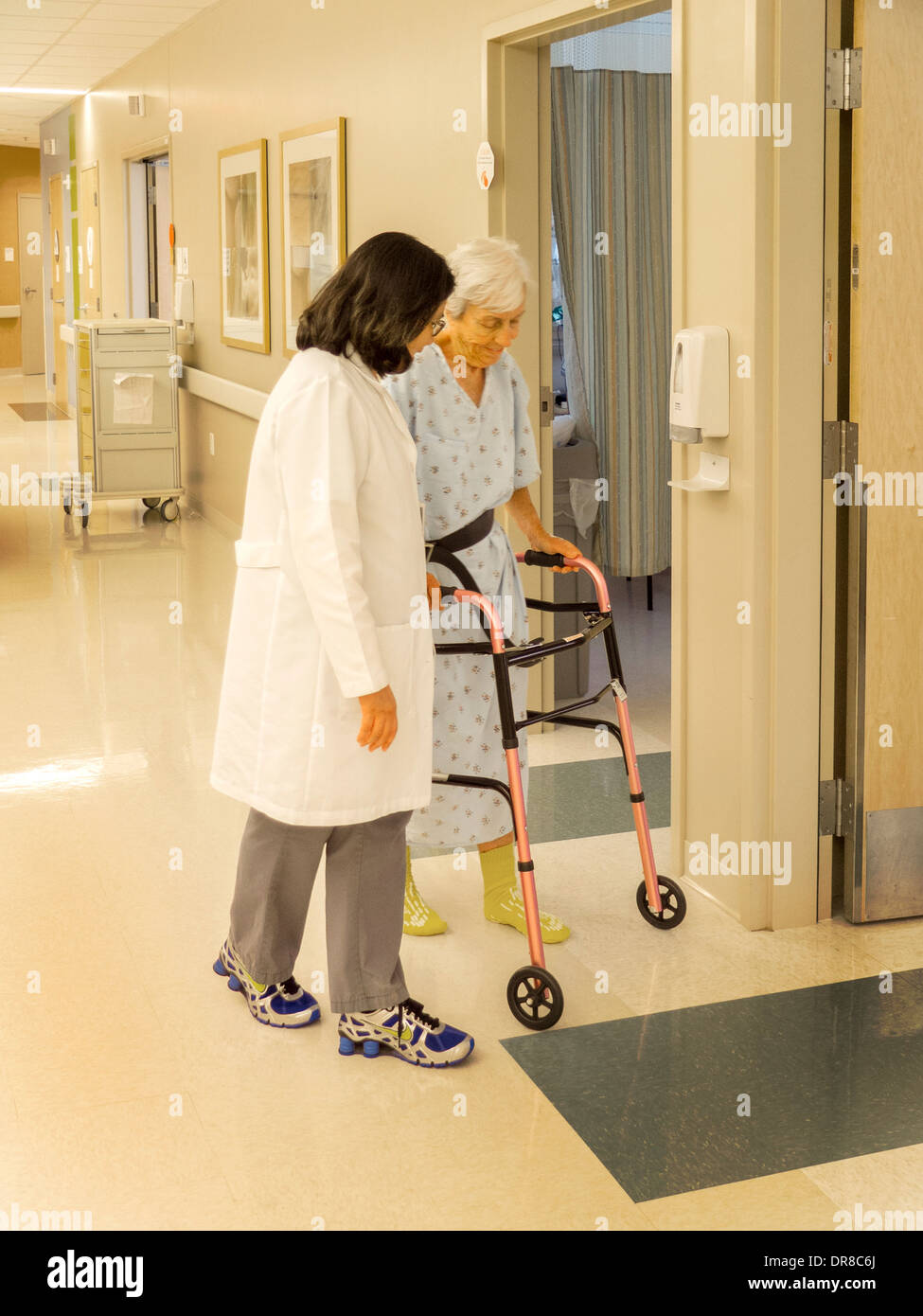 A physical therapist helps a hip surgery patient use a walker in a