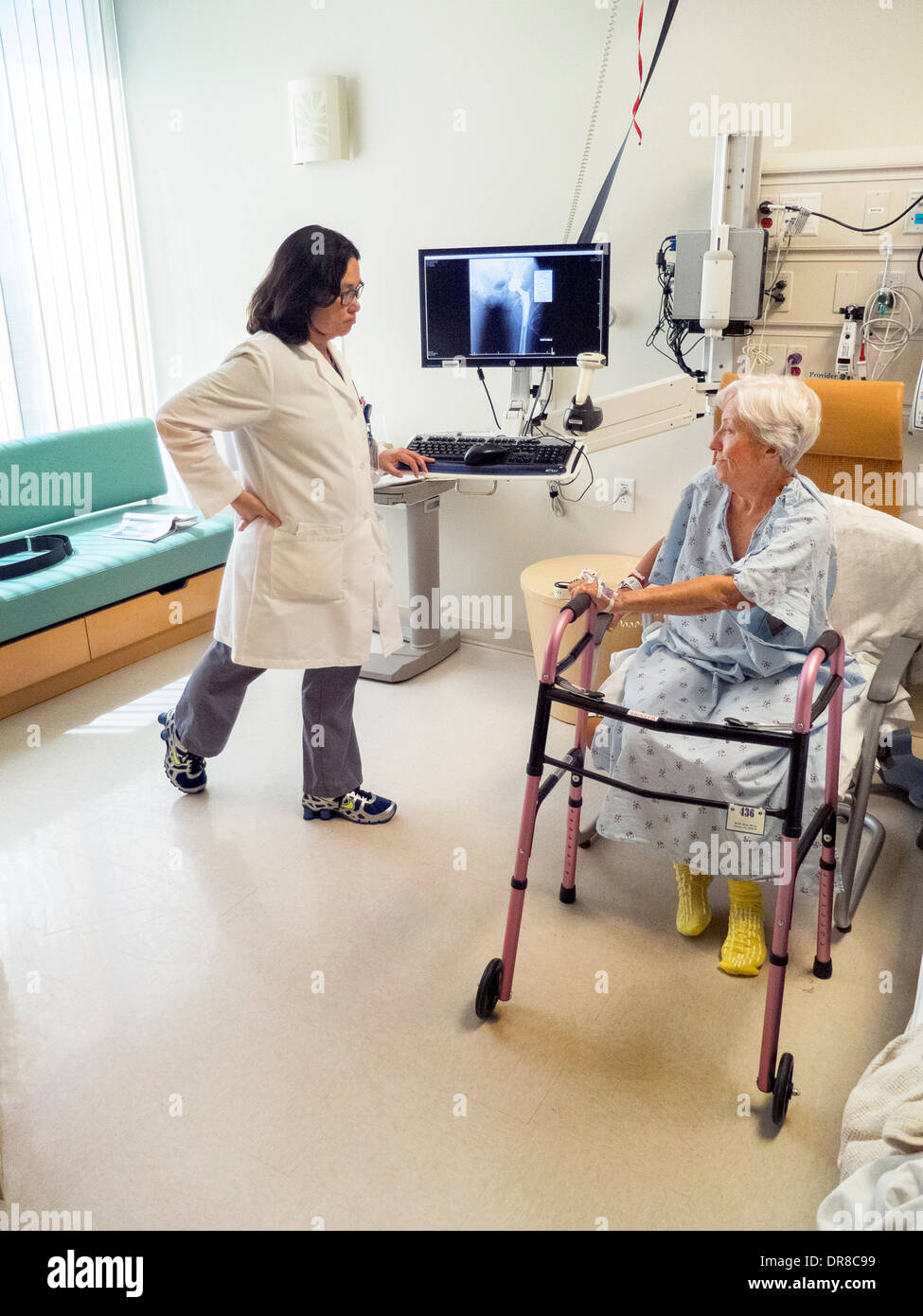 n occupational therapist demonstrates correct posture to a recovering hip replacement surgery patient at California hospital. Stock Photo