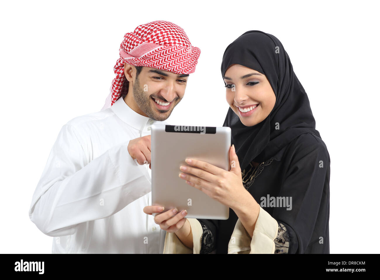 Arab saudi happy couple browsing a tablet reader isolated on a white background Stock Photo
