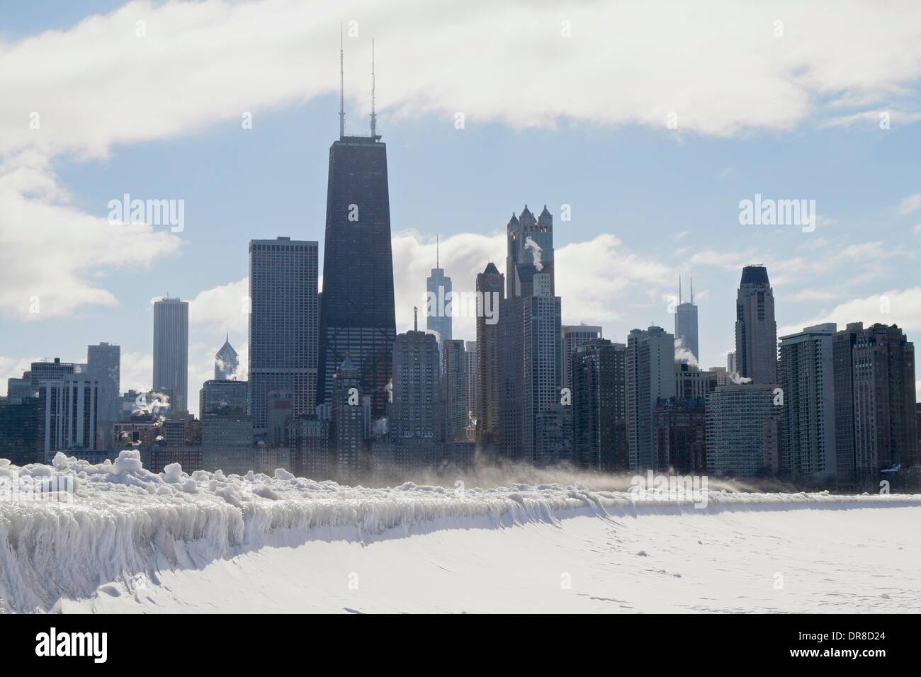 Chicago, USA. 21st January 2014. Icicles formed by waves from the latest lake effect storm drape the seawall at North Avenue Beach as snow blows in front of the city's downtown skyline. The polar vortex has returned bringing frigid temperatures. Credit: Todd Bannor/Alamy Live News Stock Photo