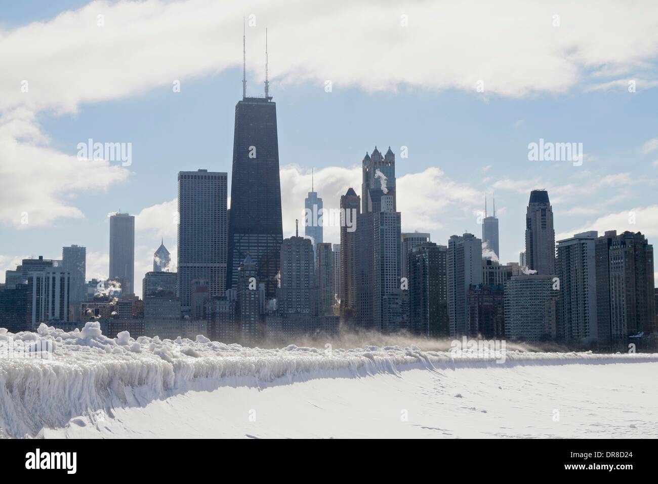 Chicago, USA. 21st January 2014.  Icicles formed by waves from the latest lake effect storm drape the seawall at North Avenue Beach as snow blows in front of the city's downtown skyline. The polar vortex has returned bringing frigid temperatures. Credit:  Todd Bannor/Alamy Live News Stock Photo