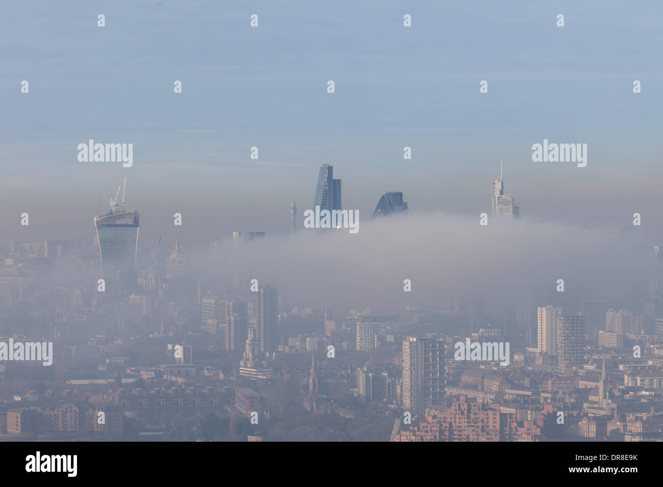 London UK, 21st Jan 2014. The tops of seven of London's tallest buildings are visible above the low fog. From left to right they are: 20 Fenchurch Street (nicknamed 'The Walkie Talkie'), the Willis Building, the BT Tower, 122 Leadenhall Street (nicknamed 'The Cheesegrater'), 30 St Mary Axe (nicknamed 'The Gherkin') with Tower 42 just behind, and the Heron Tower. This was shot from Canary Wharf to the East. © Steve Bright/Alamy Live News Credit:  Steve Bright/Alamy Live News Stock Photo