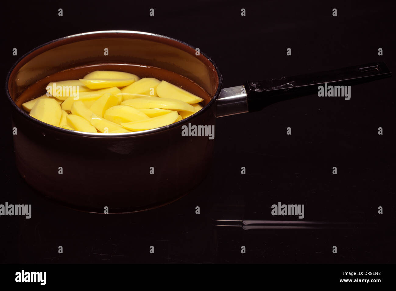 Raw peeled potatoes in pot on black Stock Photo Alamy