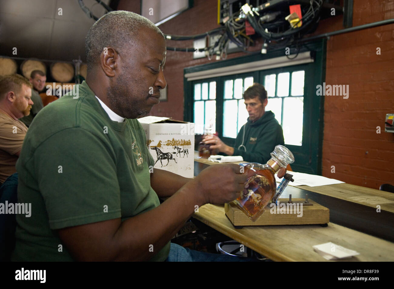 Employee at Buffalo Trace Distillery Putting Label on Bottle of Blanton's Single Barrel Bourbon by Hand Stock Photo