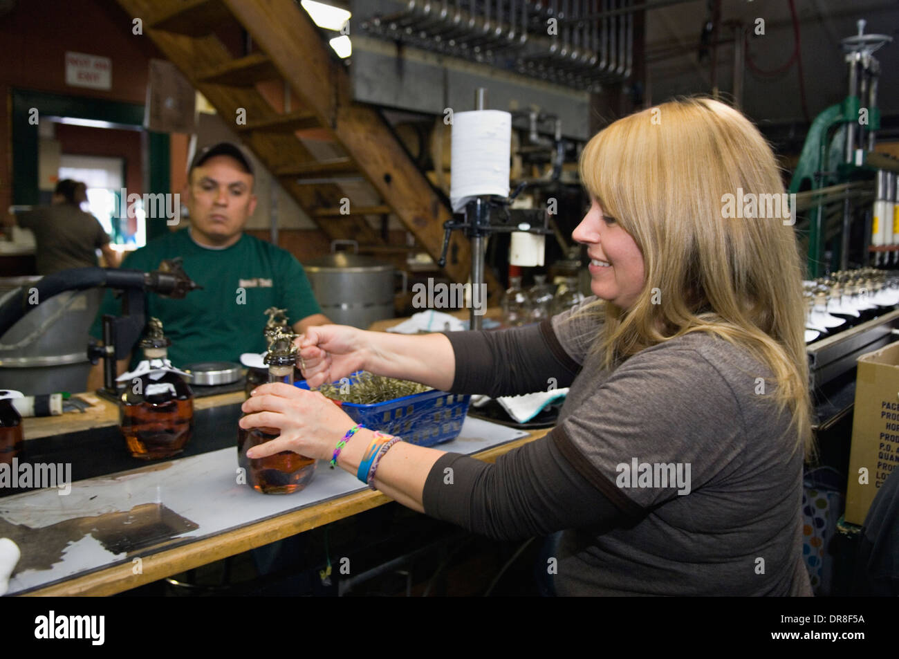 Employee at Buffalo Trace Distillery Attaching Race Horse Figurine by Hand on a Bottle of Blanton's Single Barrel Bourbon Stock Photo