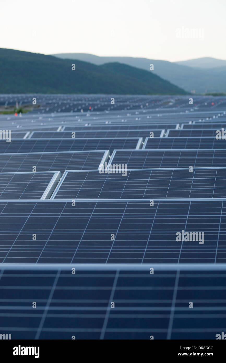 The sun sets on a field of solar panes near the completion of installation in Adams, Massachusetts. Stock Photo