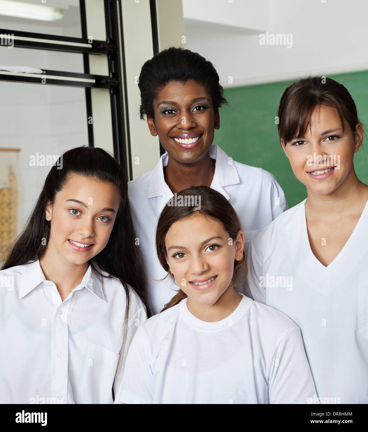 Teacher Standing With Schoolgirls In Lab Stock Photo