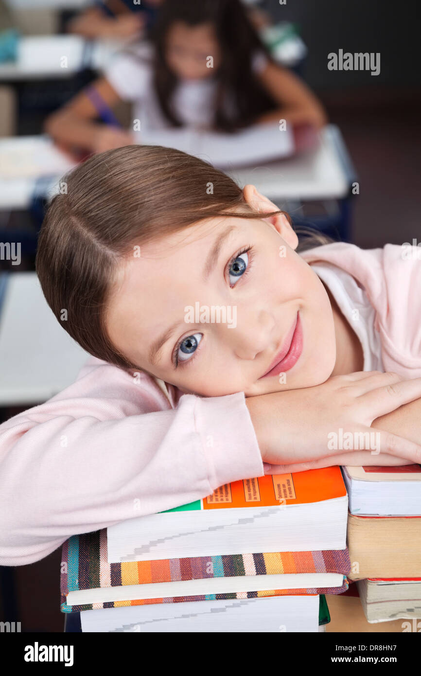 Happy Schoolgirl Leaning On Stack Of Books Stock Photo - Alamy