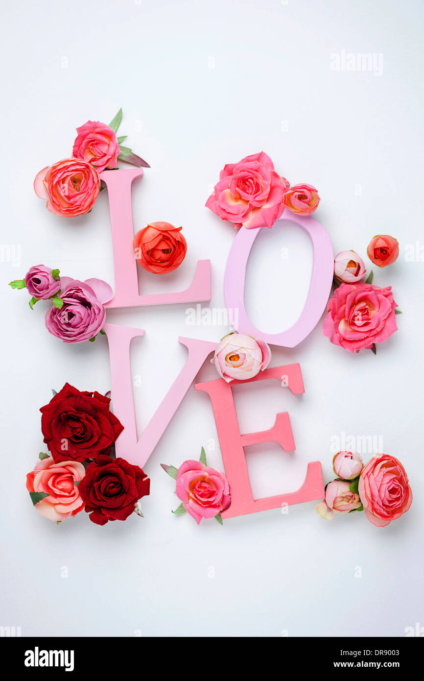 a letter saying love with roses around Stock Photo