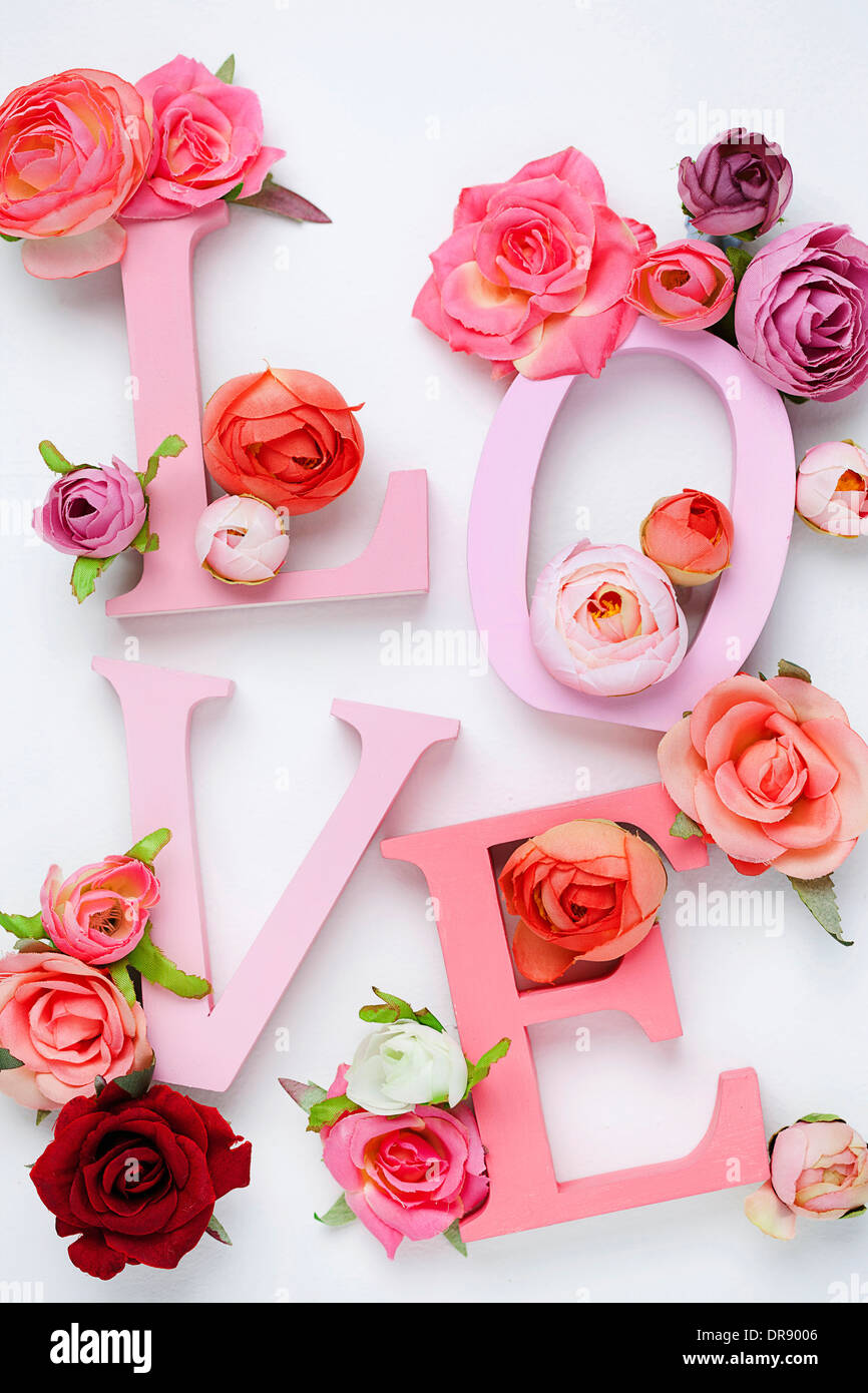 a letter saying love with roses around Stock Photo