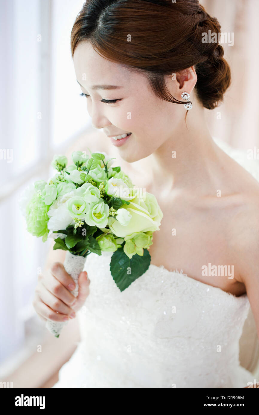 a woman posing with wedding dress and flower bouquet Stock Photo - Alamy
