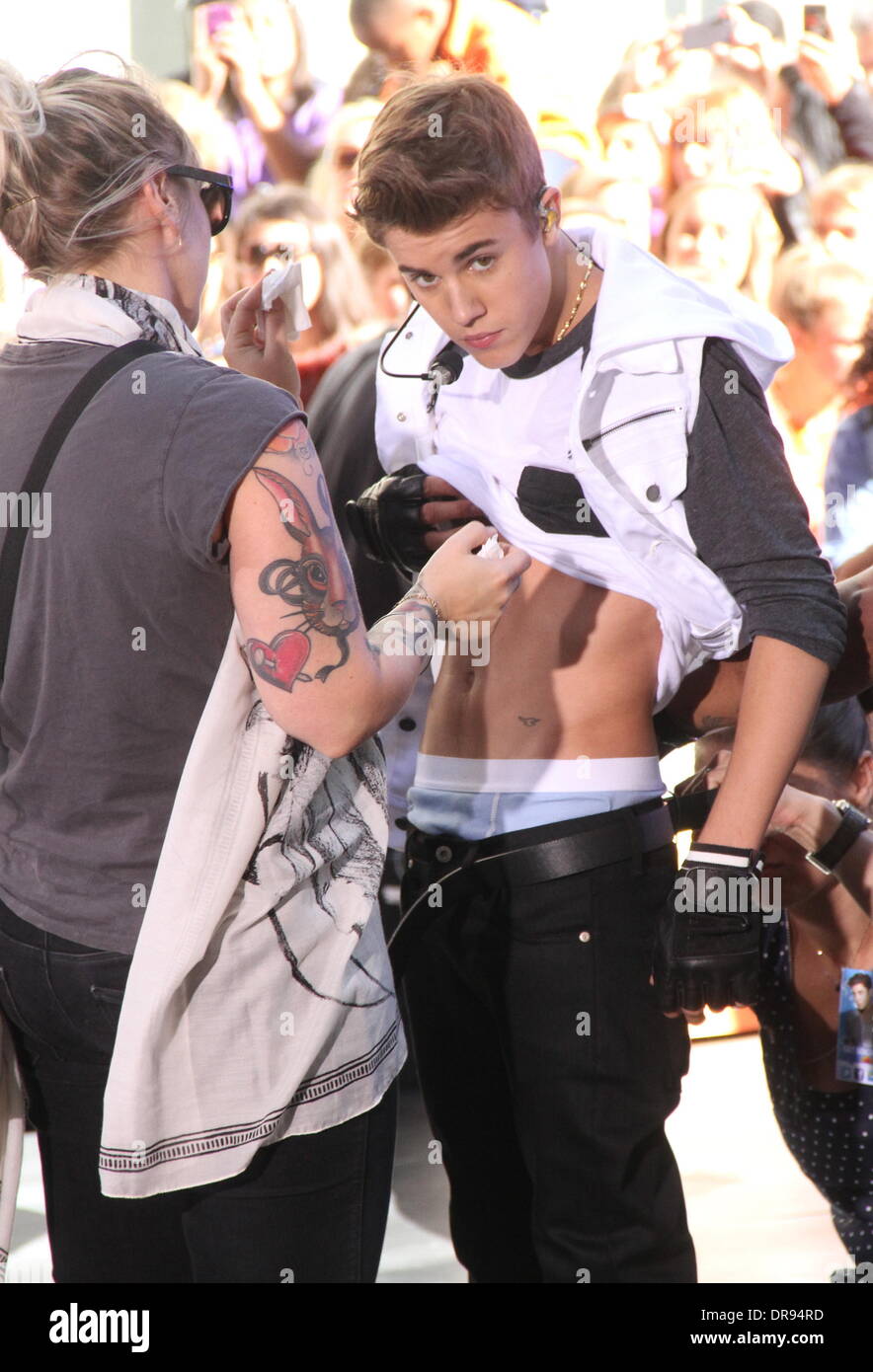 Justin Bieber changes his jeans at a commercial break, with the help of his handlers, during his performance on the 'Today' show's concert series at Rockefeller Center. Bieber revealed a small tattoo