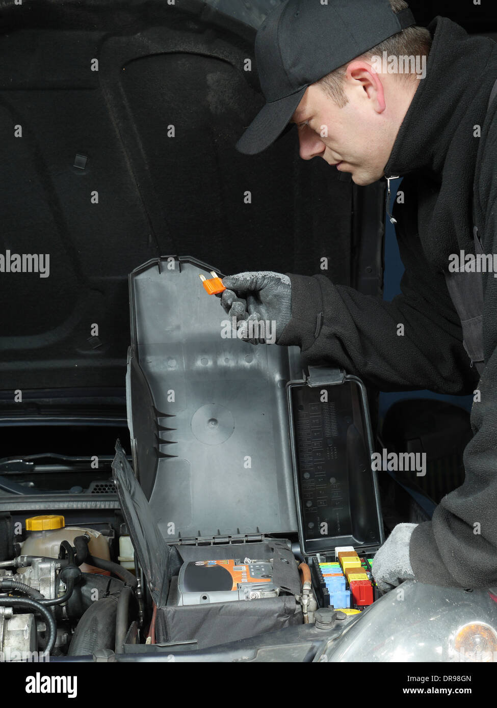 Auto mechanic checking a car fuse Stock Photo