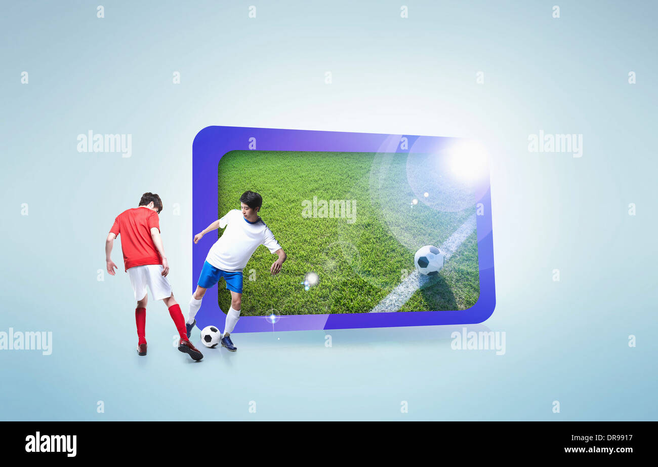 two soccer players next to a screen with a field Stock Photo