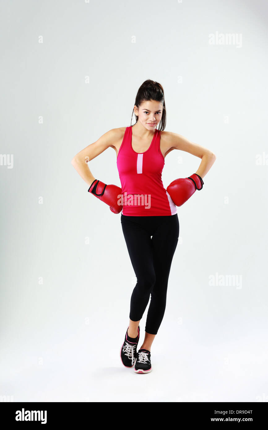 Young happy sports woman standing with boxing gloves on gray background Stock Photo