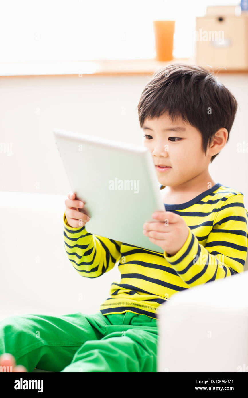 a boy playing with a tablet Stock Photo