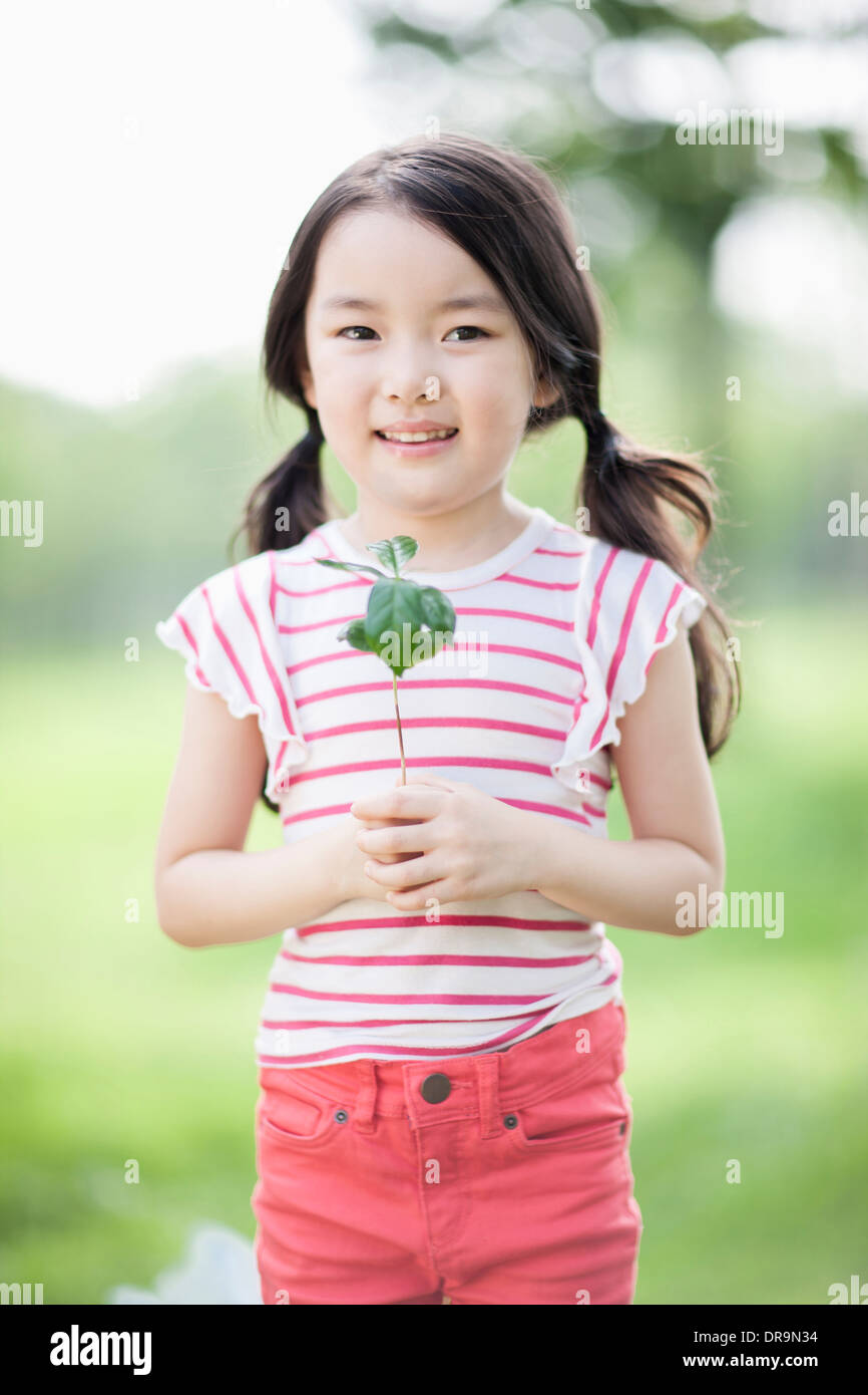 a girl holding a plant Stock Photo