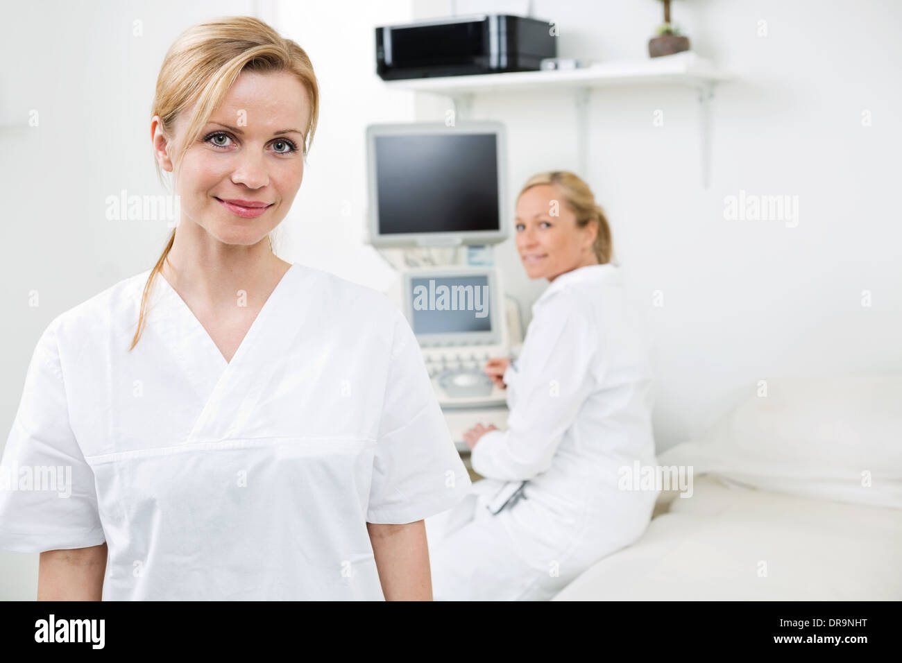 Happy Female Gynecologist With Colleague In Background Stock Photo Alamy