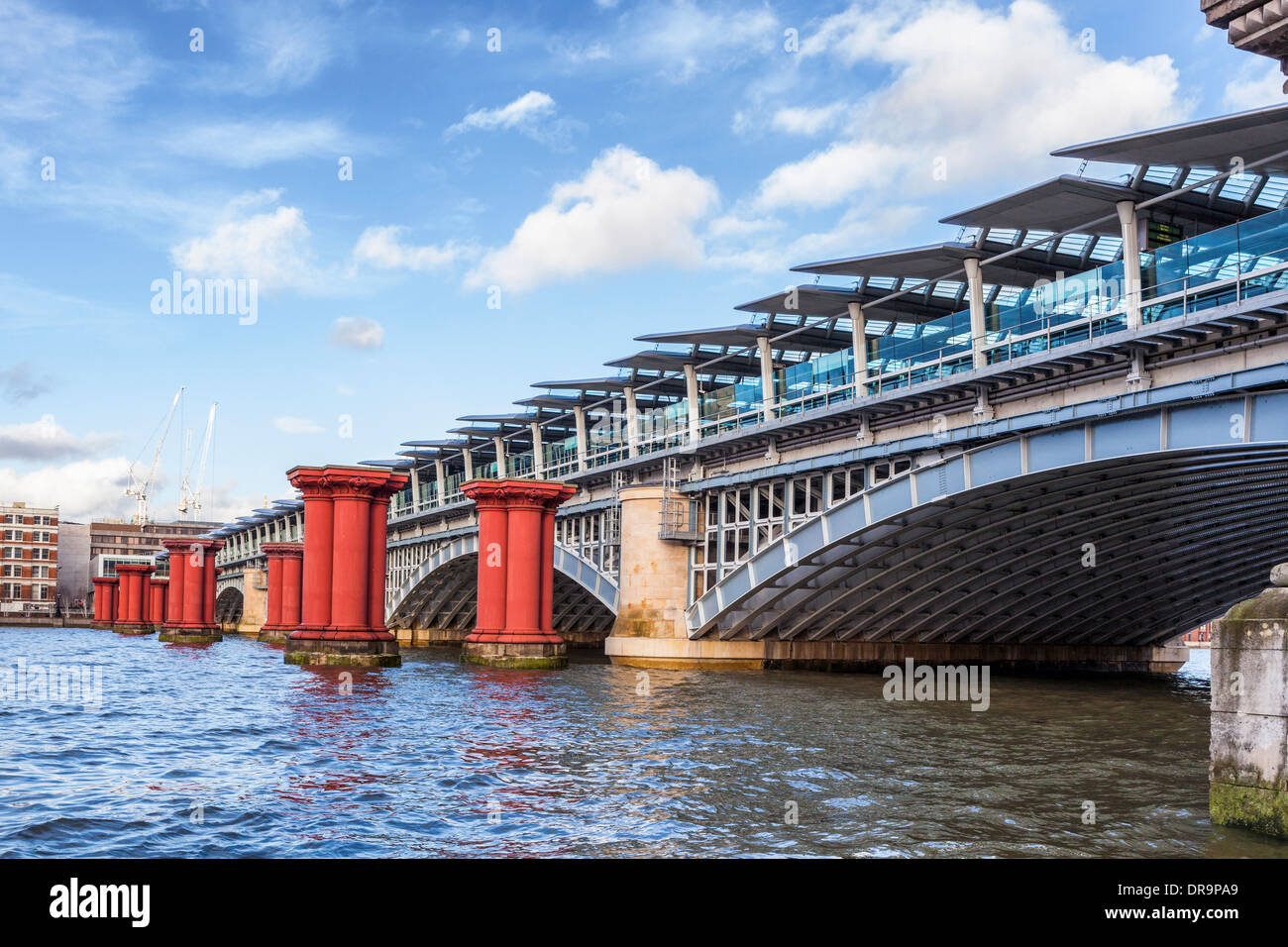 Modern Blackfriars railway station with solar energy panels and orange pillars of the old rail bridge, Thames river, London, UK Stock Photo