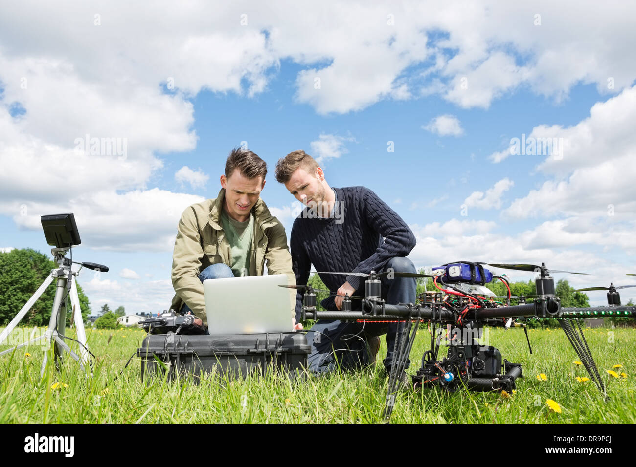 Technicians Working On Laptop By UAV in Park Stock Photo