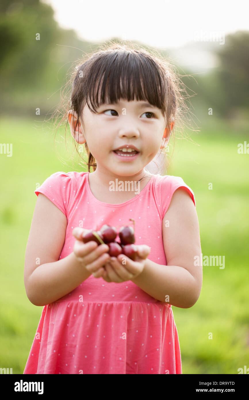 a girl holding a bunch of cherries Stock Photo - Alamy