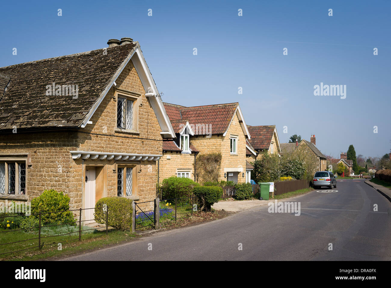 Derry Hill village in Wiltshire UK showing several modern properties faced with natural stone Stock Photo