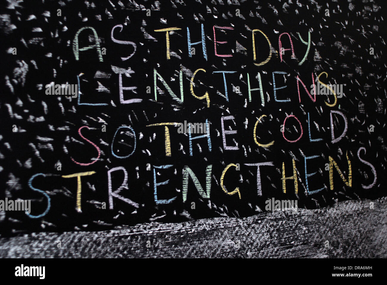 chalk writing - As the day lengthens so the cold strengthens.- words written on blackboard. Stock Photo