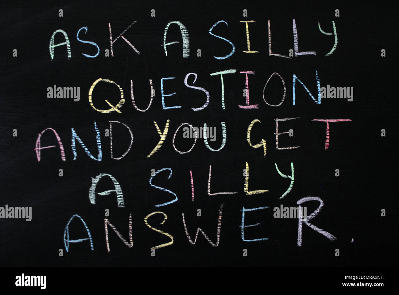 chalk writing on a blackboard- Ask a silly question and you get a silly answer Stock Photo