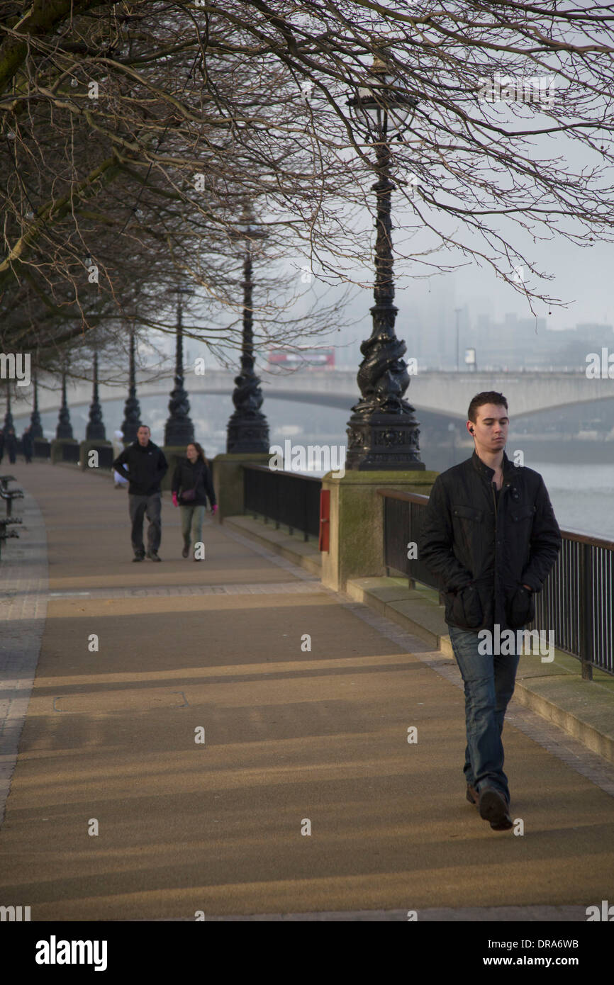 People walking along the famous riverfront walkway on winter light on the Southbank. South Bank is a significant arts and entertainment district, it's riverside walkway busy with visitors and tourists. London, UK. Stock Photo