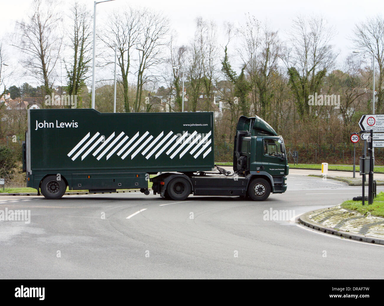 An articulated John Lewis truck traveling around a roundabout in Coulsdon, Surrey, England Stock Photo
