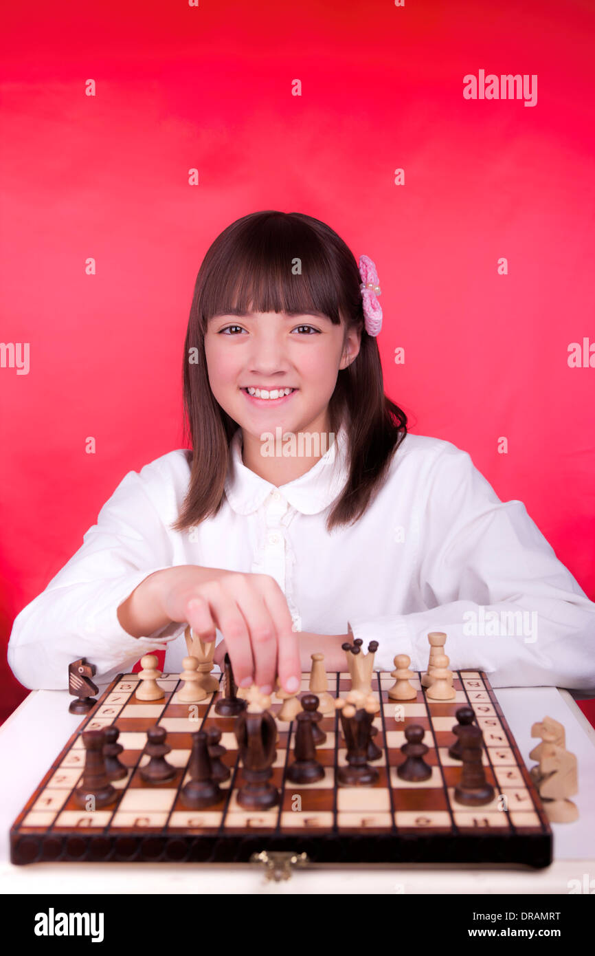 Girl moves chess piece Stock Photo - Alamy