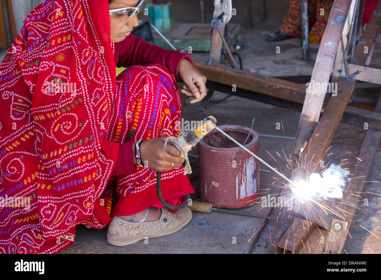 Women welding joints during the construction of solar cookers at the