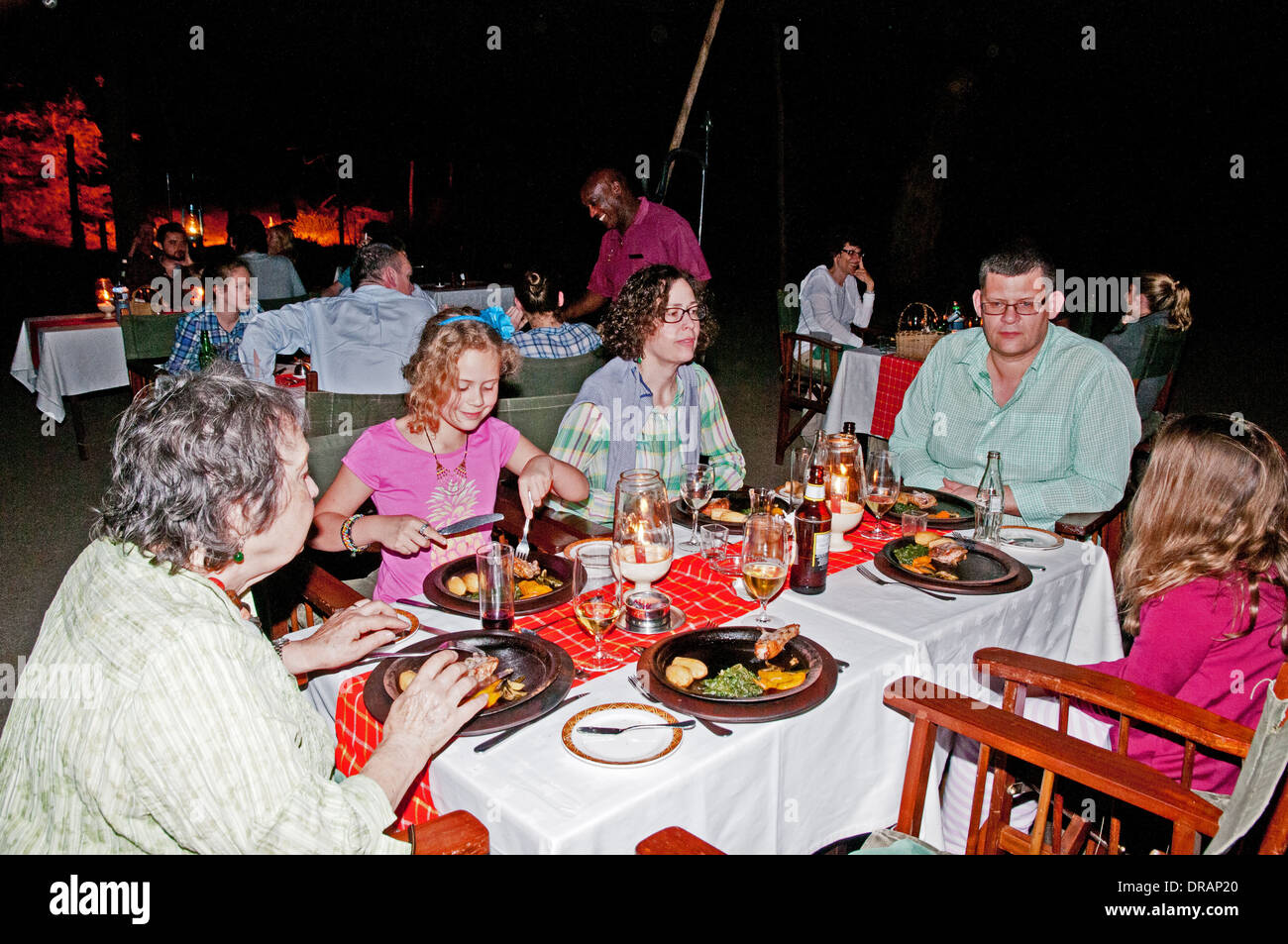 Amboseli Serena Lodge diners at open air outside evening barbeque in Amboseli National Park Kenya East Africa Stock Photo