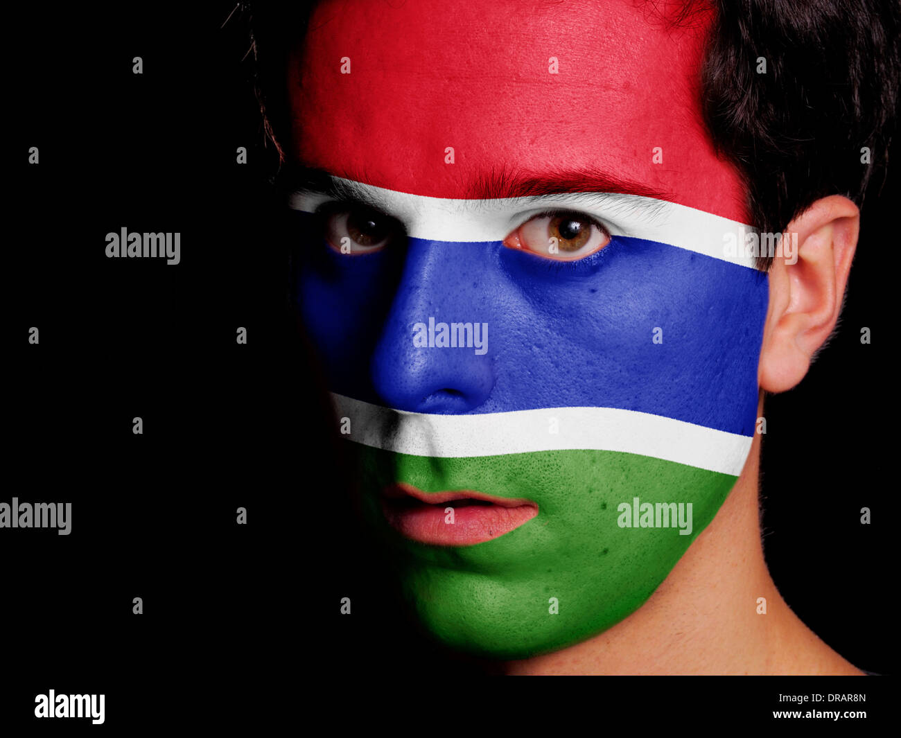 Flag of Gambia Painted on a Face of a Young Man Stock Photo