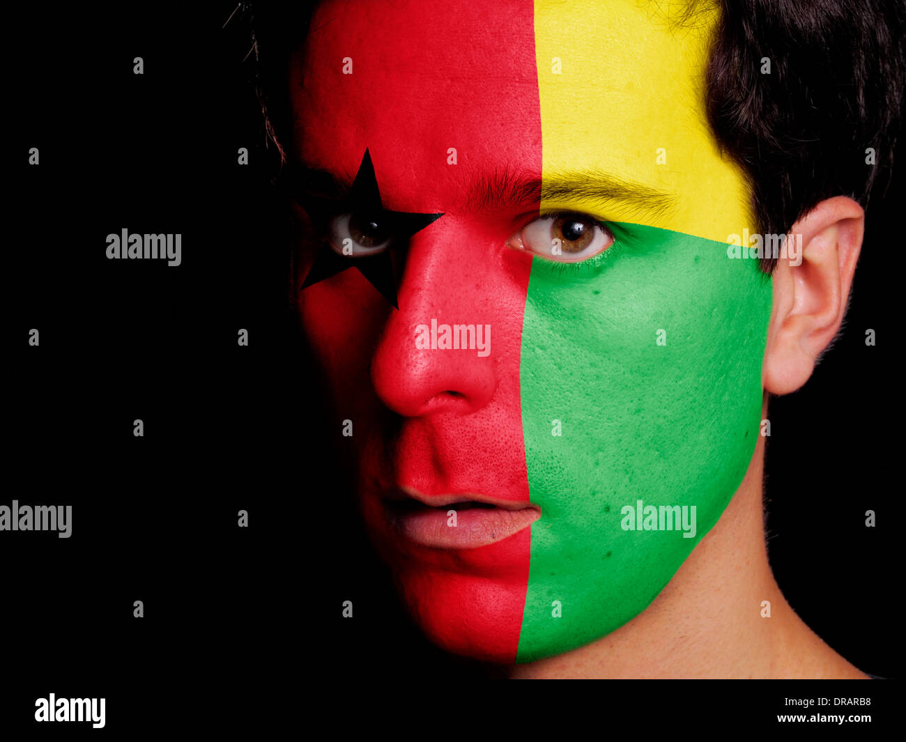 Flag of Guinea-Bissau Painted on a Face of a Young Man Stock Photo