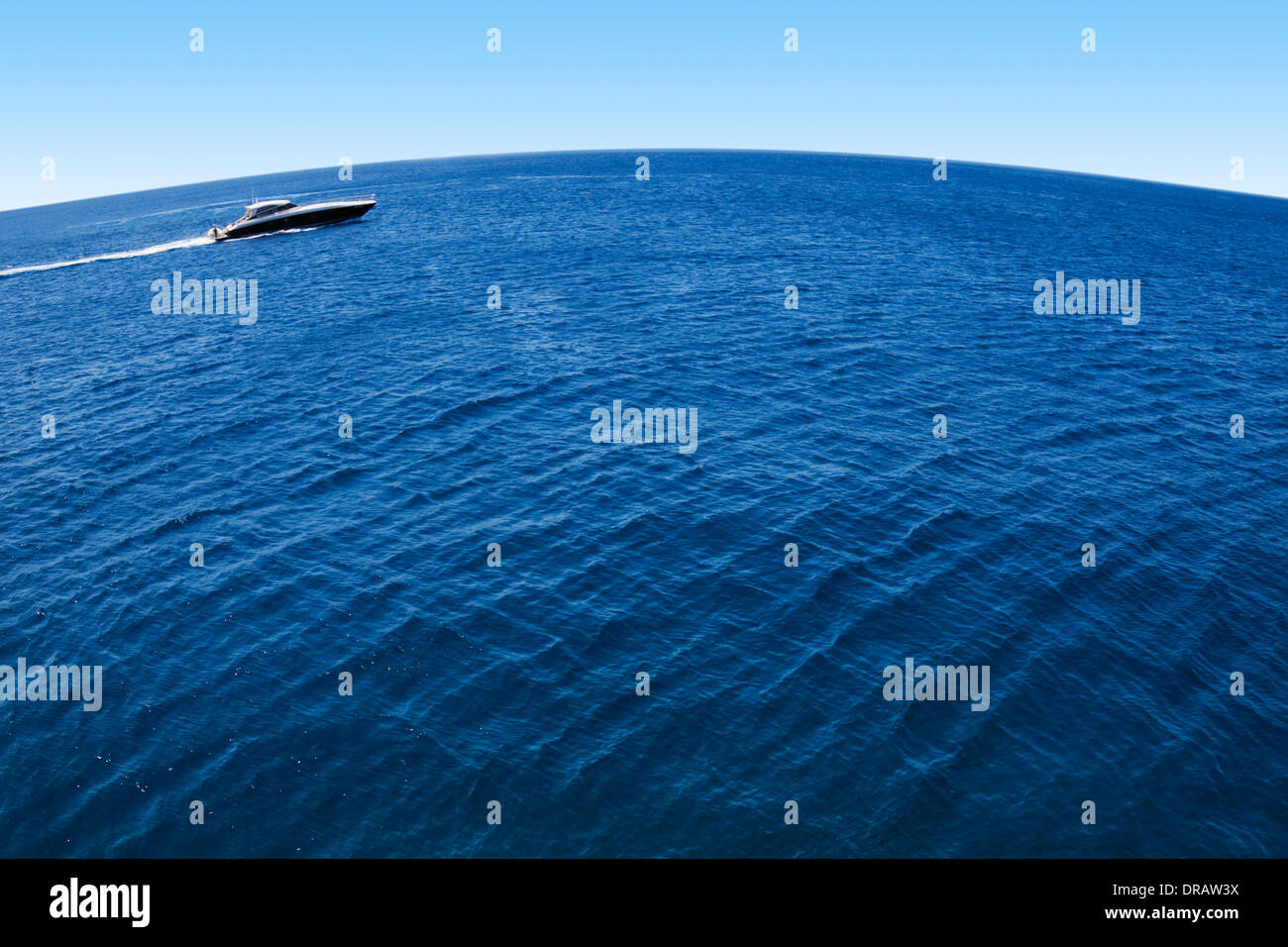 A motor yacht drives through the blue planet Stock Photo