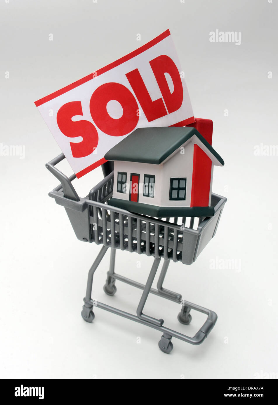 HOUSE IN SUPERMARKET TROLLEY WITH SOLD SIGN RE THE ECONOMY HOME BUYERS HOUSING MARKET  MORTGAGES FIRST TIME HOUSEHOLD INCOMES UK Stock Photo
