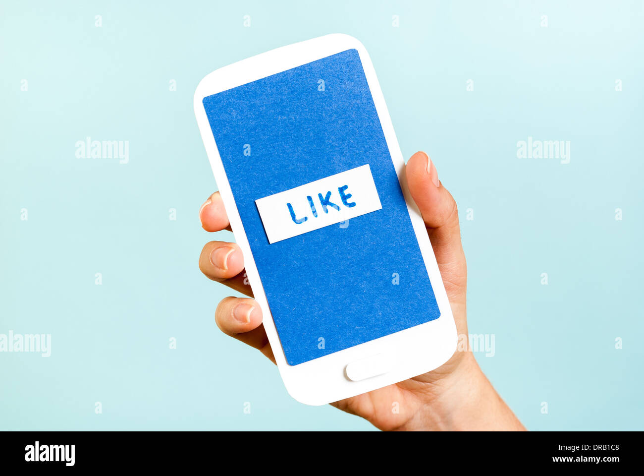 Conceptual smartphone showing like button on blue background Stock Photo