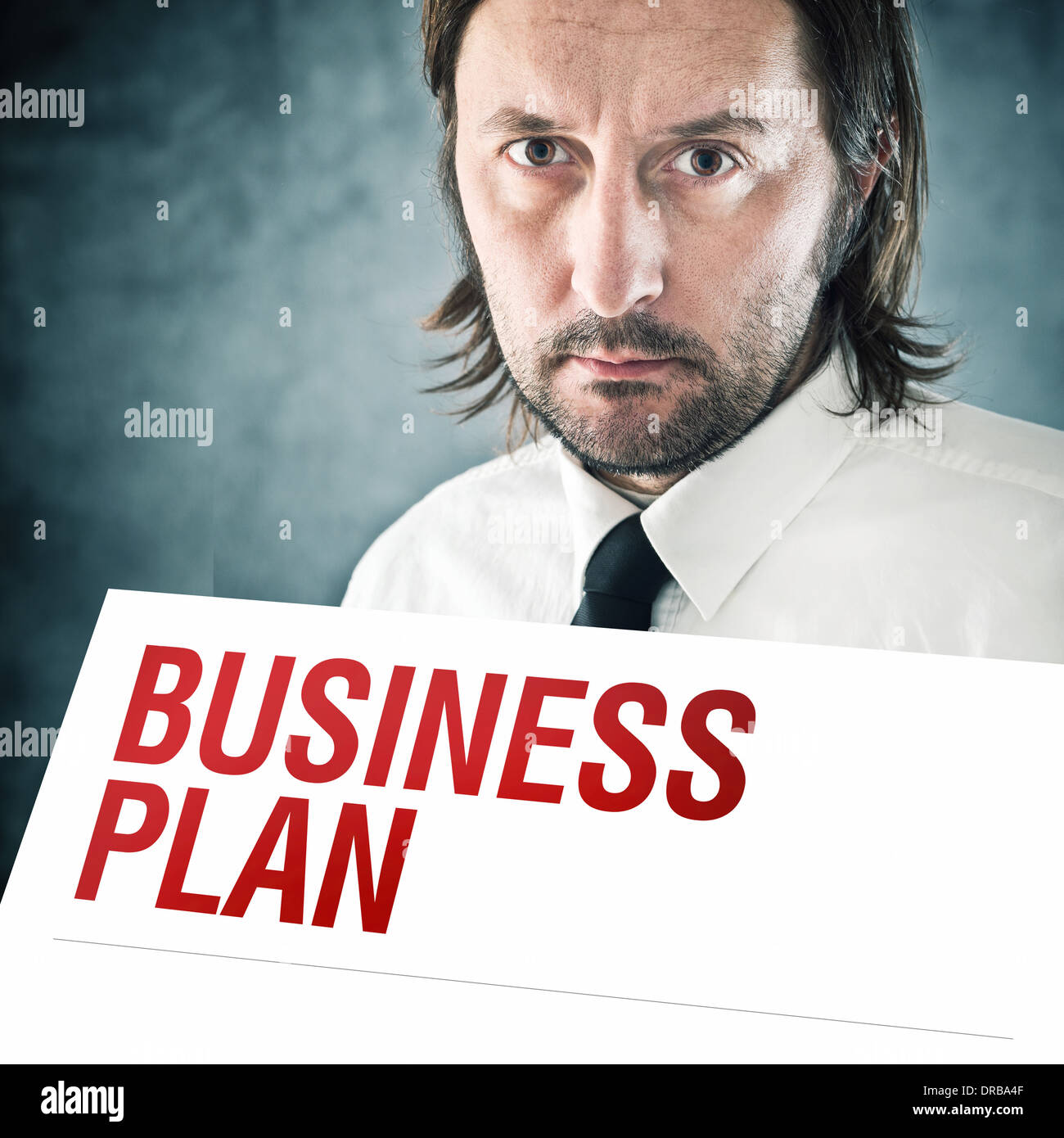 Businessman holding poster with business plan printed title. Business strategy concept. Stock Photo