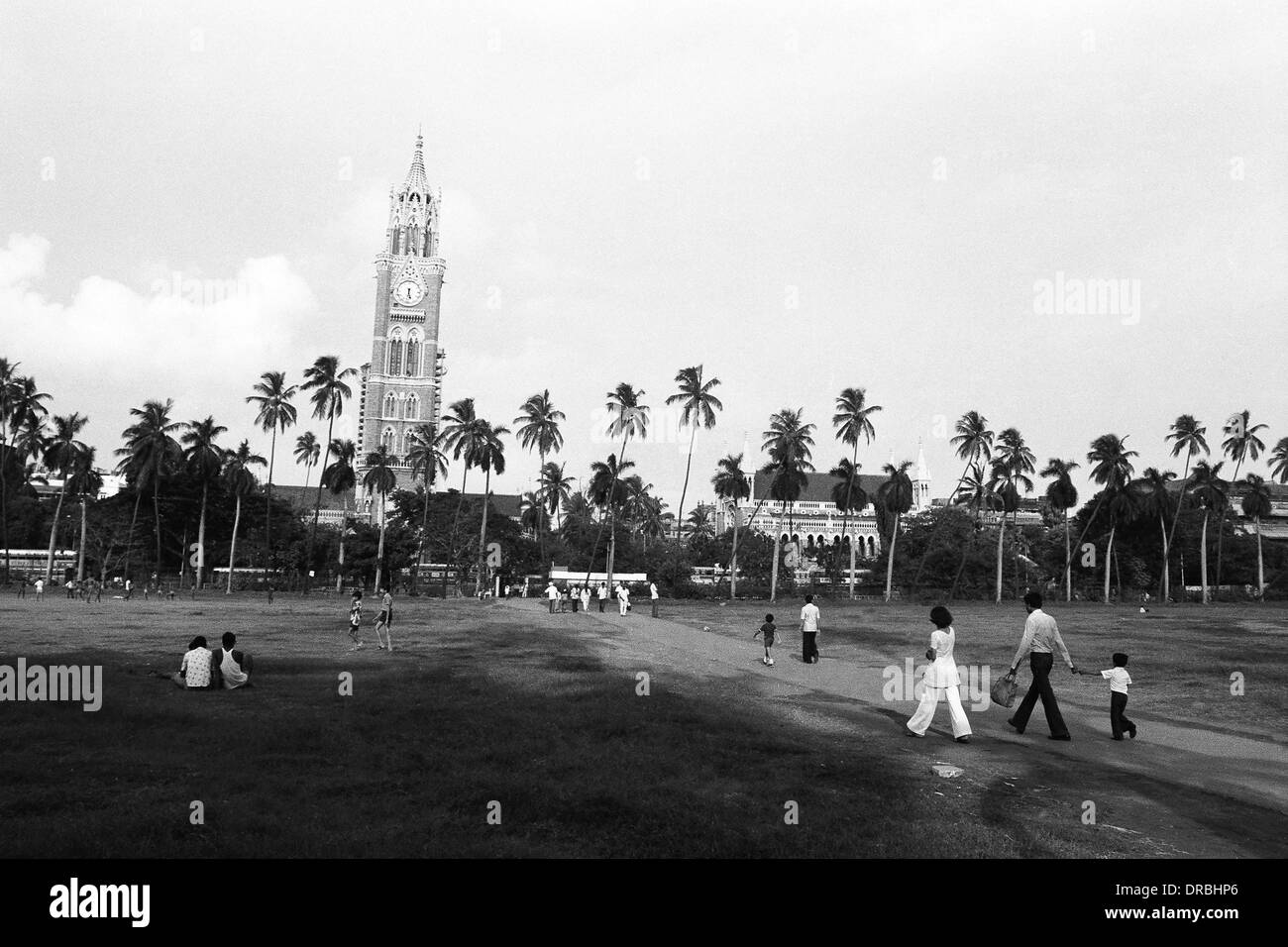 Family crossing Oval Maidan to Rajabhai Tower, Mumbai, Maharashtra, India, 1979 Stock Photo