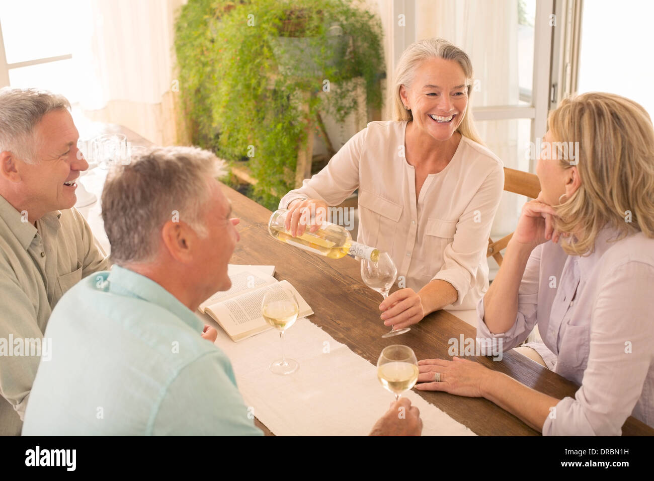 Senior couples drinking wine at dining table Stock Photo
