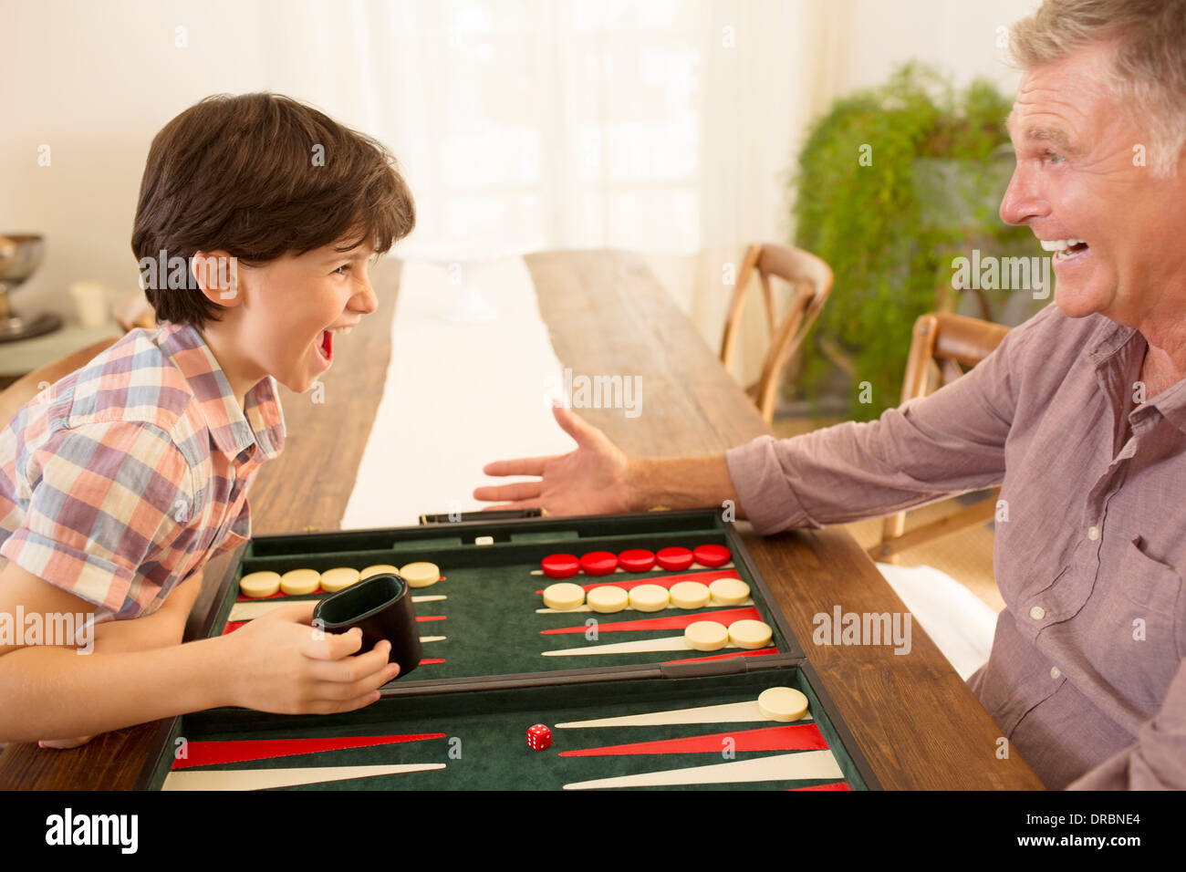 Grandfather and grandson playing backgammon Stock Photo