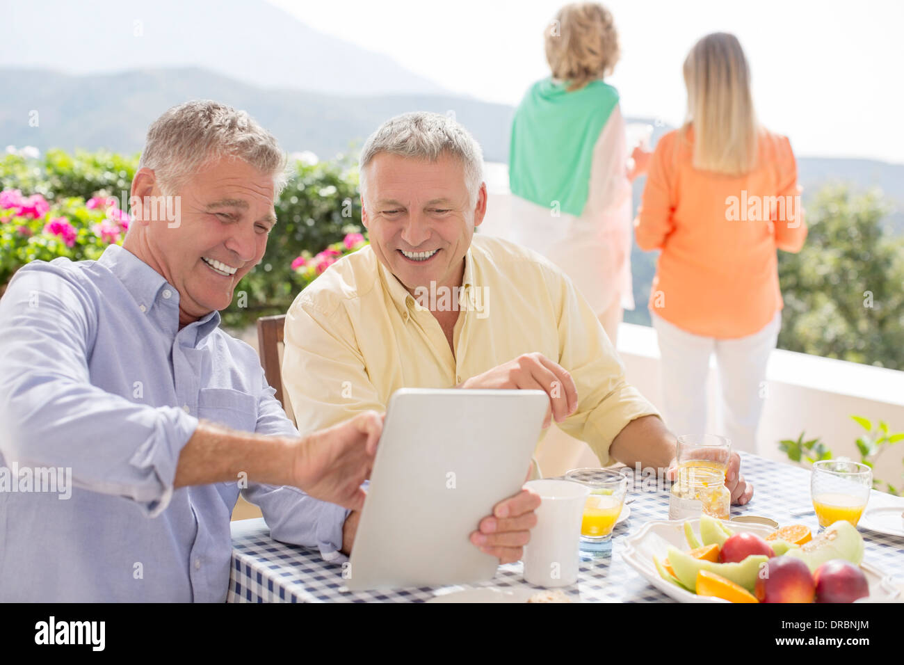 Senior men using digital tablet at patio table Stock Photo