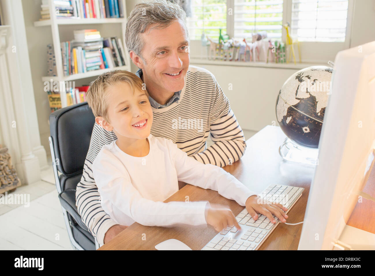 Father and son using computer together Stock Photo - Alamy